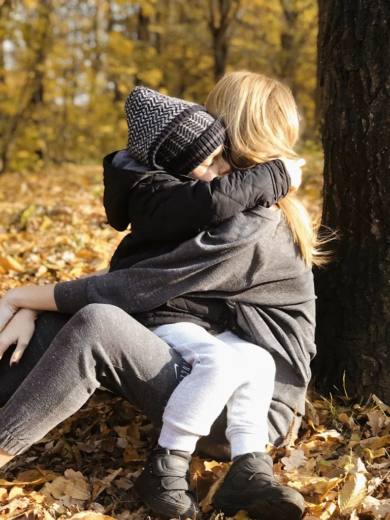 Alleinerziehend: innige Umarmung im herbstlichen Park – Nähe, Ruhe und Sicherheit