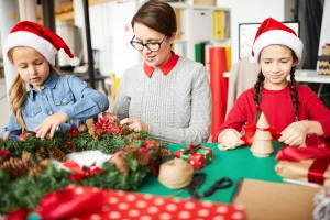 Adventskranz basteln mit Kindern: Erwachsene und zwei Kinder gestalten gemeinsam einen weihnachtlichen Kranz.