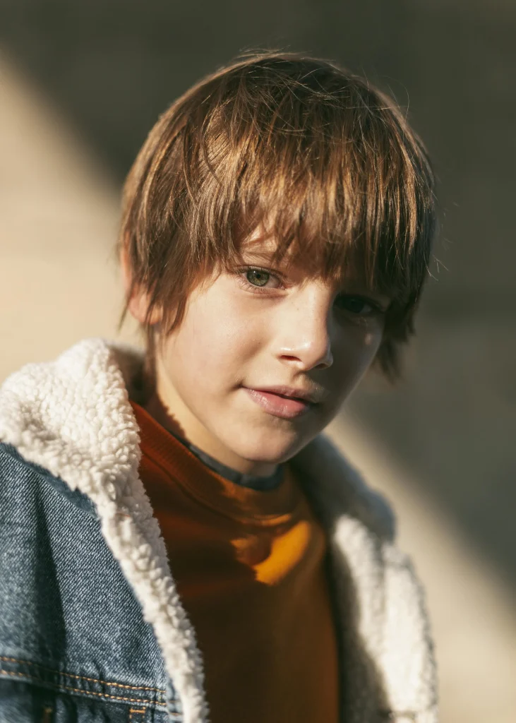 Junge mit natürlicher, mittellanger Jungs Frisur 2026 mit lässigem Pony im Outdoor-Look