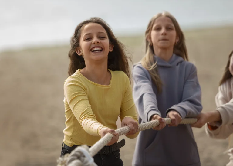 Kinder stärken ihre Resilienz beim gemeinsamen Tauziehen am Strand