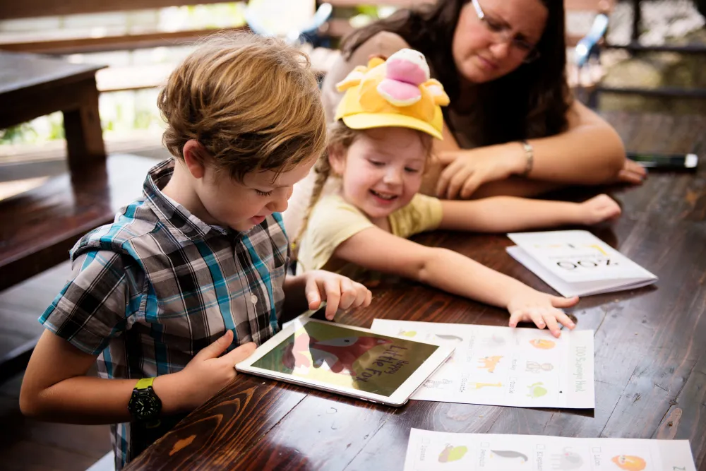 Kinder nutzen Tablet gemeinsam mit Erwachsener – Förderung von Medienkompetenz bei Kindern durch Begleitung