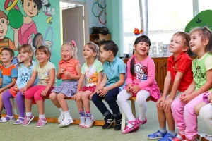 Kinder sitzen gemeinsam in einer Kita-Gruppe und spielen im Gruppenraum – Kita Gebühren 2026 Deutschland