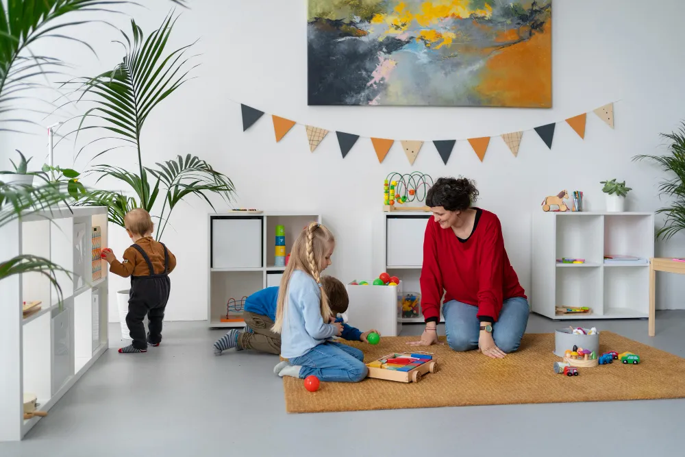 Pädagogische Fachkraft begleitet Kinder im Kita-Alltag nach dem Konzept der Bezugspädagogik.