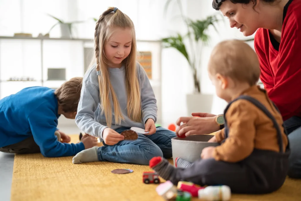 Bezugspädagogik in der Kita: Eine pädagogische Fachkraft begleitet Kinder beim gemeinsamen Spielen.